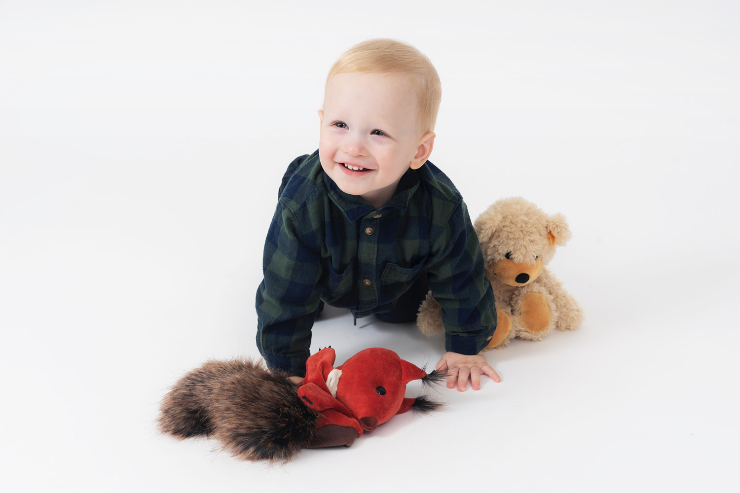 Porträt eines Kleinkindes mit seinen Kuscheltieren